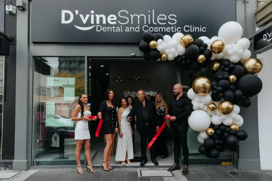 D'vine Smiles Dental and Cosmetic Clinic team celebrating grand opening in front of the clinic entrance with balloon decorations.